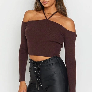 Detail of ribbed knit texture on halter off-shoulder long sleeve top in dark brown