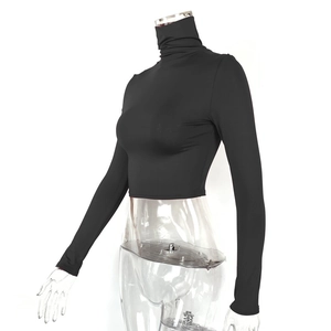 Close-up of black turtleneck crop top showing high-elasticity fabric and slim fit design