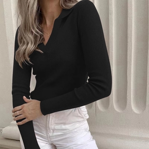 Detail eines schwarzen gerippten Langarm-Polos mit elegantem V-Ausschnitt und Textur