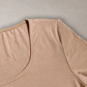 Close-up of the ribbed U-neckline and fine stitching on a nude slim-fit short sleeve T-shirt