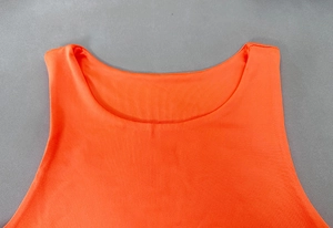 Detail of orange sleeveless bodysuit showing the ribbed knit fabric and round neckline