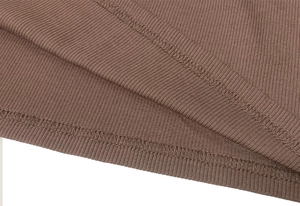 Detailed macro view of the brown ribbed knit fabric texture and hem stitching on the dress