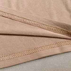 Macro view of double-stitched hem on a slim-fit khaki knit crop top showing clean seam detail