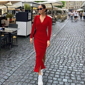 Detail of red long sleeve knit polo dress with high side slit and buttoned neckline