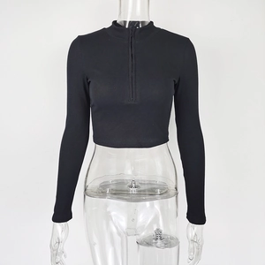 Detail of ribbed knit black cropped top with stand collar and half-zipper closure