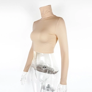 Macro detail of the nude high-neck crop top showing high-stretch knitted fabric texture