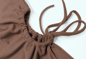 Detailed macro view of deep brown ribbed knit fabric with drawstring and ruching details