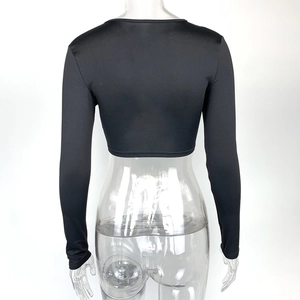 Détail du haut court noir à manches longues montrant la coupe du dos et le tissu élastique