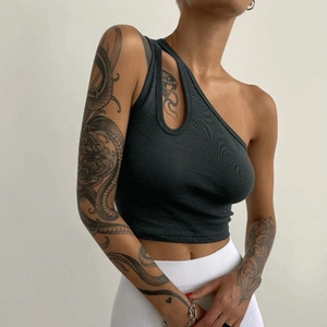 Detail of black ribbed knit crop top featuring asymmetric one-shoulder and cutout design