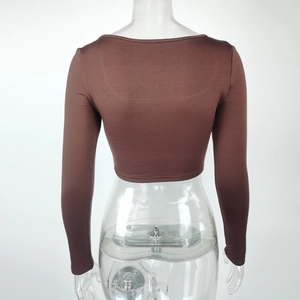 Detail view of the brown cropped long sleeve top featuring elastic form-fitting fabric