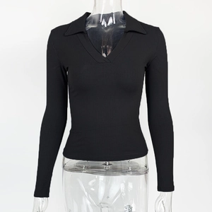 Detail eines schwarzen V-Ausschnitt Polo-Oberteils mit Rippenstruktur und Slim-Fit