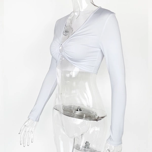 Détail d'un crop top blanc à manches longues avec anneau central et fronces