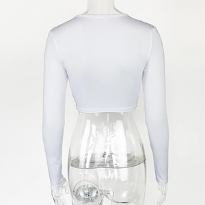 Vue arrière du crop top blanc à manches longues montrant la coupe ajustée et le tissu