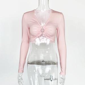 Détail d'un crop top rose à manches longues avec décolleté en V, anneau et fronces