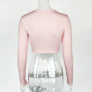 Vue arrière du haut court rose à manches longues et coupe ajustée sur mannequin clair