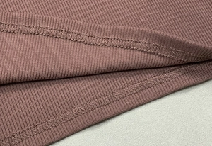 Detailed macro view of the ribbed knit hem and professional stitching on the crop top
