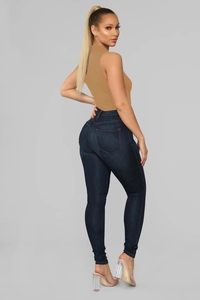 Detail shot of navy blue high-waisted skinny jeans and khaki sleeveless bodysuit