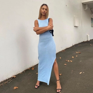 Detailed close-up of light blue ribbed knit fabric and high side slit on maxi dress