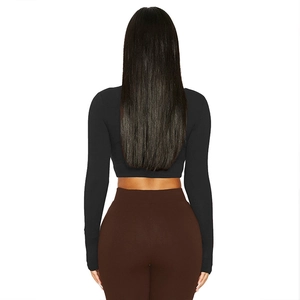 Rear view of tight-fitting black long sleeve crop top and high-waisted brown leggings