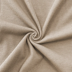 Macro detail of the beige ribbed knit fabric showing soft texture and elastic weave