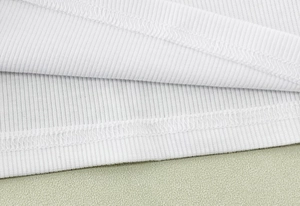 Gros plan sur la texture en tricot côtelé blanc avec détails de couture à double aiguille