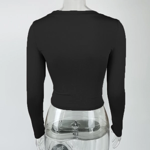 Close-up of the black ribbed knit fabric and back view of the slim fit long sleeve crop top