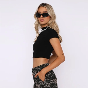 Detail of black slim fit crop top featuring high neck and rib knit texture in Y2K style