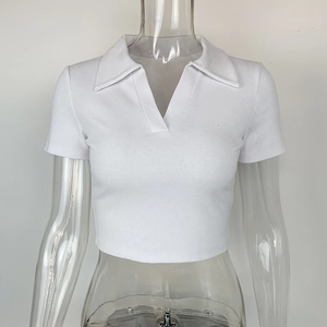 Détail du tissu en maille côtelée blanche et du col polo en V classique sur le crop top ajusté