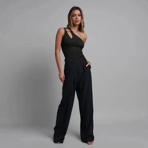 Detail eines schwarzen One-Shoulder-Bodys mit Cut-Out und passender weit geschnittener Hose