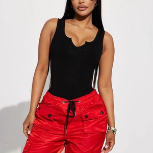 Détail d'un body noir côtelé à col en V assorti d'un pantalon cargo en satin rouge