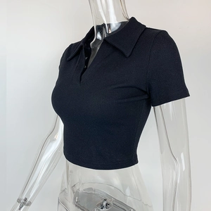 Détail du crop top noir en maille côtelée avec col polo et décolleté en V ajusté