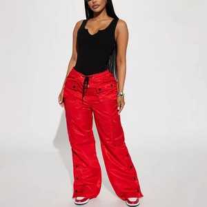 Détail du body noir à col en V avec un pantalon cargo rouge à plusieurs poches latérales