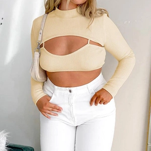 Detail van een beige geribbelde gebreide tweedelige set met bolero en een cutout top
