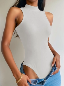 Detail view of white ribbed mock neck bodysuit showing seamless fit and textured fabric