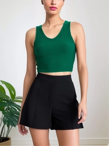 Sleeveless emerald green ribbed V-neck tank top paired with black high-waisted shorts