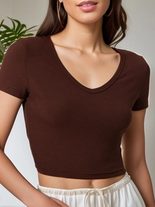 Dettaglio del crop top marrone in maglia a costine con scollo a V e trama verticale fine