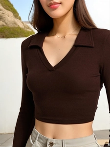 Detail of dark brown ribbed knit texture and lapel V-neck design on long sleeve crop top