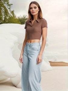 Close-up of brown ribbed knit polo crop top paired with high waist light blue denim jeans