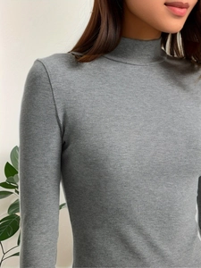 Detailed view of the ribbed knit texture and turtleneck design of the grey slim dress