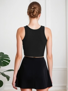 Detail view of the black ribbed crop top and A-line skirt texture from the back