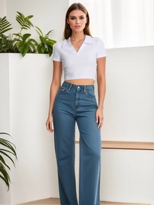 Detail of white ribbed crop polo top and high-waist wide-leg jeans on female model