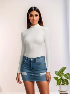 Détail d'un body blanc à col montant côtelé et d'une mini-jupe en jean déchirée