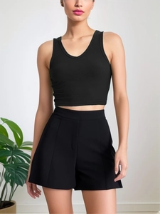 Detail of a black ribbed V-neck crop top paired with high-waisted wide-leg shorts