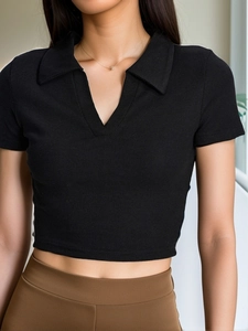 Close-up of black ribbed knit polo crop top with V-neck collar and slim fit detail