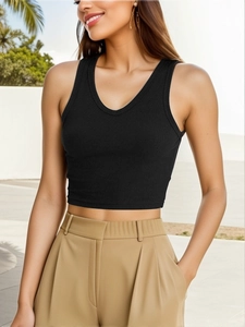 Women's black ribbed cotton V-neck crop top vest tank in a modern outdoor lifestyle setting