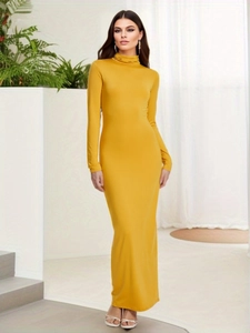Detail of the elegant mustard yellow turtleneck and soft stretch fabric of the slim maxi dress