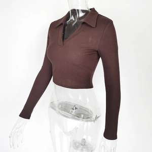 Detail view of the ribbed knit fabric and slim-fit long sleeves of the brown polo crop top