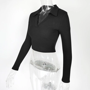 Detail of the black ribbed knit fabric and polo collar on a slim-fit cropped top