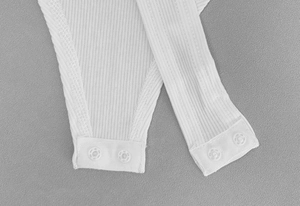 Detailopname van de dubbele drukknoopsluiting op een witte geribbelde bodysuit