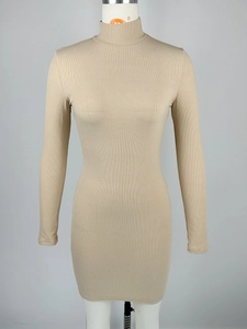 Macro detail of beige ribbed knit texture and mock neck collar on a bodycon dress
